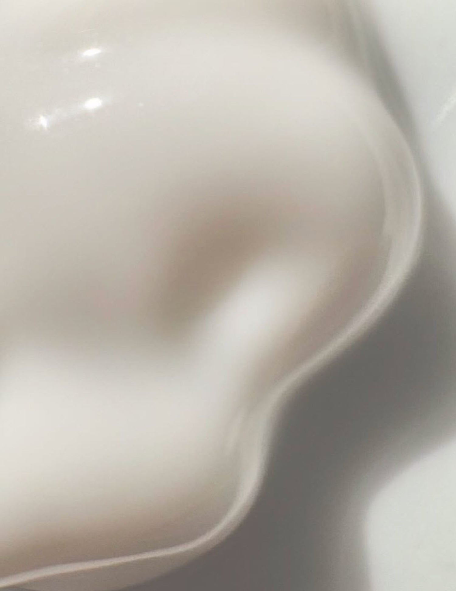 Abstract soft-focus image with curved lines and diffused light, evoking a sense of calm and minimalist beauty, IMEAN skincare.
