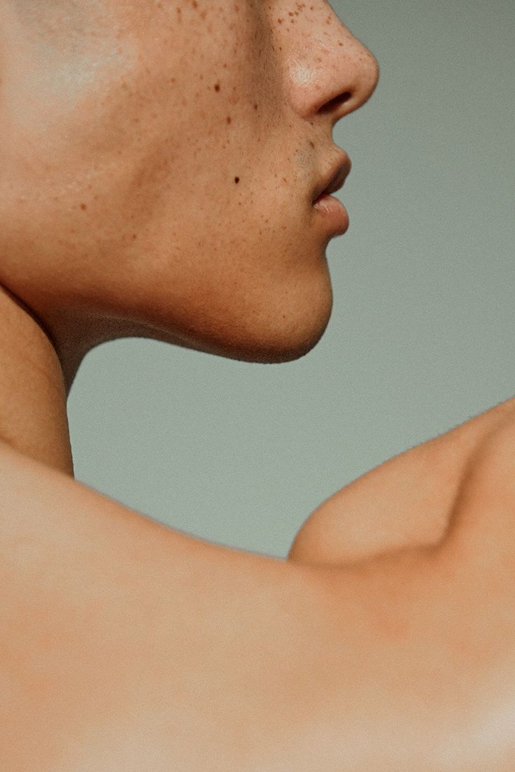Minimalist close-up of a person's chin and neck against a neutral background, capturing the essence of genderless skincare in IMEAN’s visual identity.