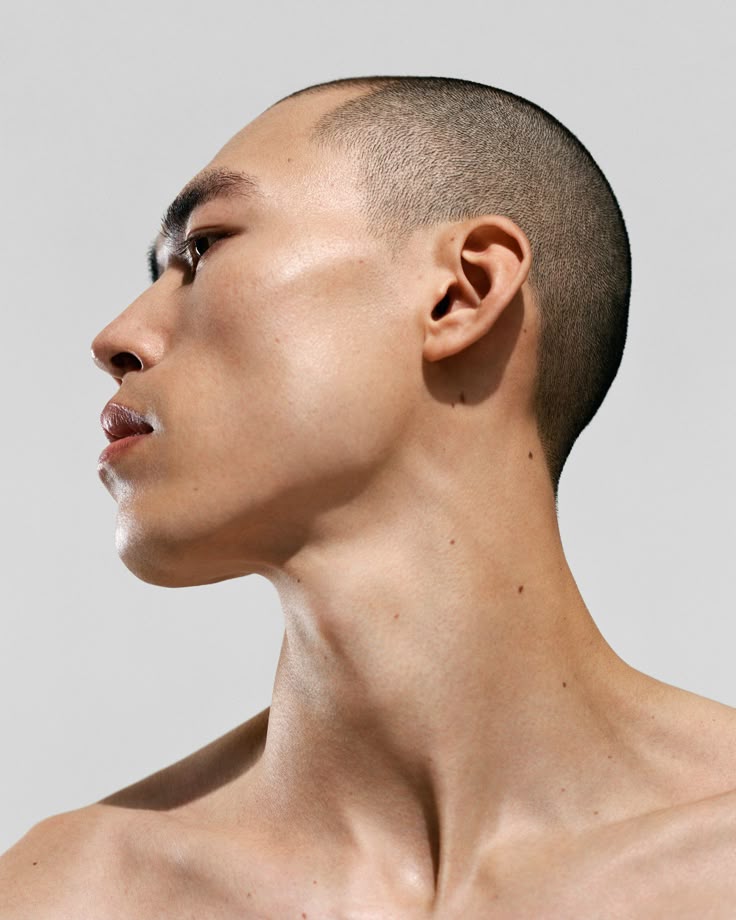 Profile of a person’s sculpted jawline and neck under soft lighting, emphasizing clear skin and minimalist skincare by IMEAN Beauty.