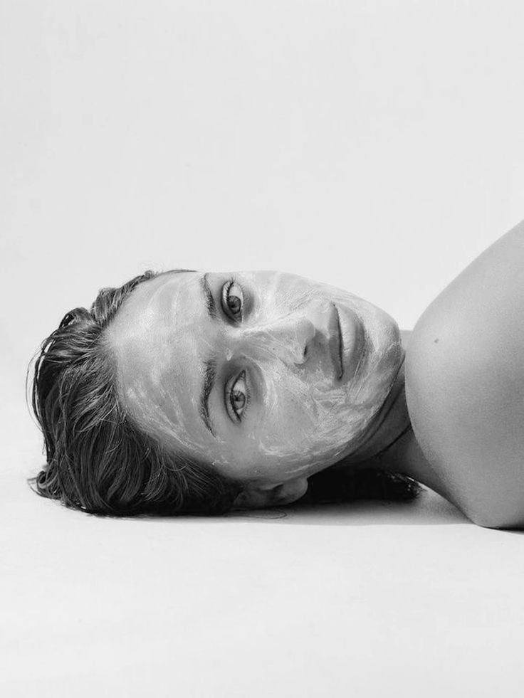Black and white portrait of a woman lying down with a creamy face treatment, illustrating skin barrier care from IMEAN Beauty skincare guide.