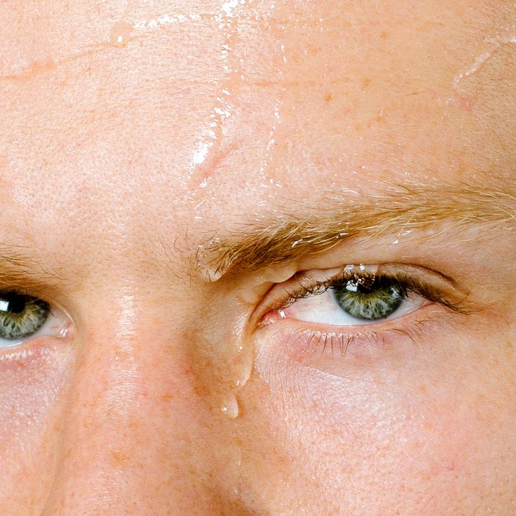 Extreme close-up of a person’s eyes and forehead with water droplets, highlighting natural skin texture and inclusive beauty ideals by IMEAN.