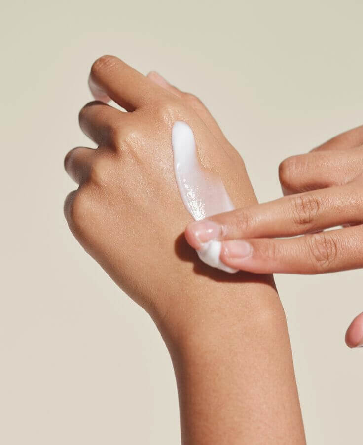Applying bioengineered natural peptide cream to hand for moisturized and healthy skin with IMEAN skincare. 