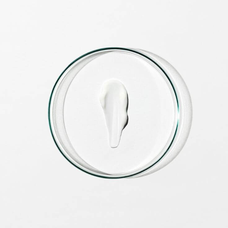 Cream sample of IMEAN bioengineered skincare placed on a glass petri dish for clean beauty formulation. 