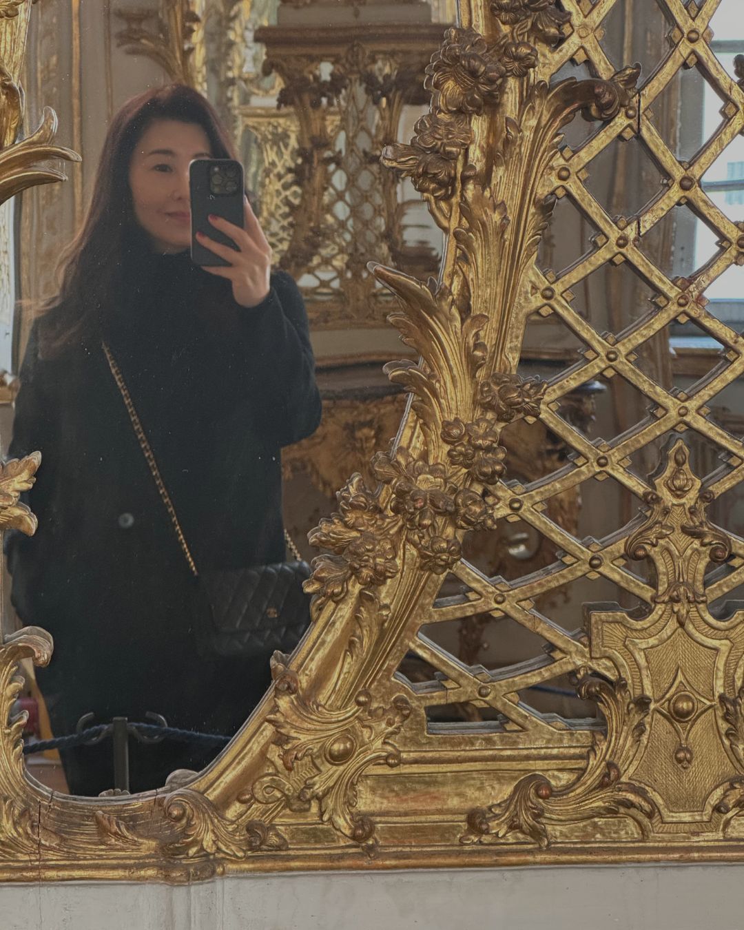 Sarah Choi, founder of IMEAN, taking a mirror selfie in front of an ornate gilded mirror at a Munich museum — a personal capture featured in Sarah’s Edit to Munich, Germany from the IMEAN Beauty travel guide.